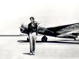 Amelia Earhart standing in front of the Lockheed Electra in which she disappeared in July 1937. Born in Atchison, Kansas in 1897, Amelia Earhart did not begin flying until after her move to California in 1920. After taking lessons from aviation pioneer Neta Snook in a Curtiss Jenny, Earhart set out to break flying records, breaking the women altitude records in 1922. Earhart continually promoted women in aviation and in 1928 was invited to be the first women to fly across the Atlantic. Accompanying pilots Wilmer Stultz and Louis Gordon as a passenger on the Fokker Friendship, Earhart became an international celebrity after the completion of the flight. In May 1932 Earhart became the first woman to fly solo across in the Atlantic. In 1935 she completed the first solo flight from Hawaii to California. In the meantime Earhart continued to promote aviation and helped found the group, the Ninety-Nines, an organization dedicated to female aviators. On June 1, 1937, Earhart and navigator, Fred Noonan, left Miami, Florida on an around the world flight. Earhart, Noonan and their Lockheed Electra disappeared after a stop in Lae, New Guinea on June 29, 1937. Earhart had only 7,000 miles of her trip remaining when she disappeared. While a great deal of mystery surrounds the disappearance of Amelia Earhart, her contributions to aviation and womens issues have inspired people over 80 years.